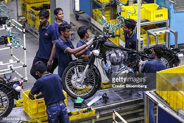 Employees assemble a Royal Enfield Motors Ltd. Classic 350 motorcycle moving on a conveyor on the production line at the company's manufacturing...
