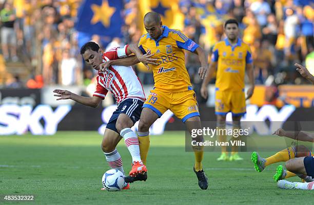 Omar Bravo of Chivas struggles for the ball with Guido Pizarro of Chivas during a 3rd round match between Tigres UANL and Chivas as part of the...