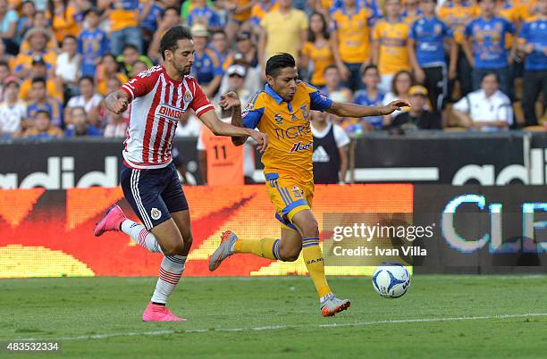 Javier Aquino of Tigres competes for the ball with Edwin Hernandez of Chivas during a 3rd round match between Tigres UANL and Chivas as part of the...