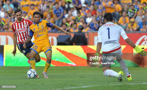 Javier Aquino of Tigres competes for the ball with Edwin Hernandez of Chivas during a 3rd round match between Tigres UANL and Chivas as part of the...