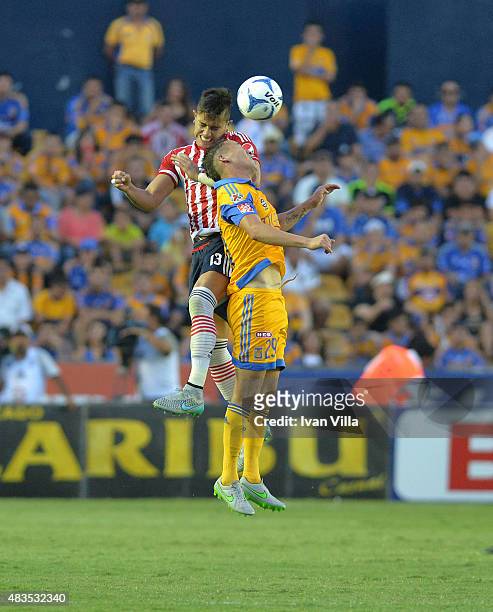 Jesus Dueñas of Tigres competes for the ball with Carlos Salcedo of Chivas during a 3rd round match between Tigres UANL and Chivas as part of the...