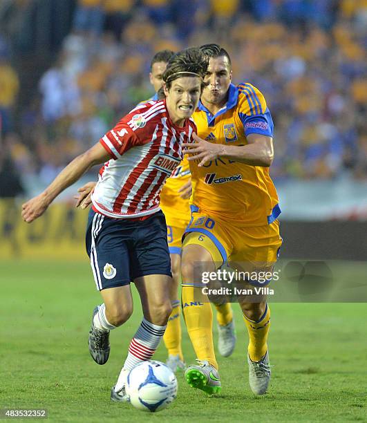 Carlos Fierro of Chivas struggles for the ball with Jorge Torres of Tigres during a 3rd round match between Tigres UANL and Chivas as part of the...