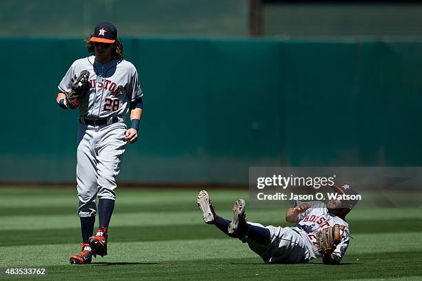 Colby Rasmus of the Houston Astros catches a fly ball hit off the bat of Brett Lawrie of the Oakland Athletics while colliding with Jose Altuve...