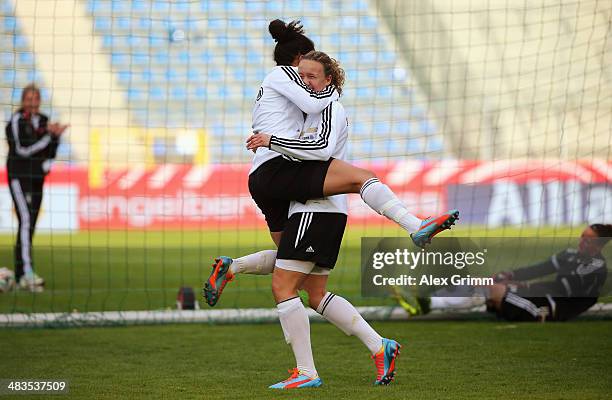Celia Sasic celebrates a goal with team mate Josephine Henning during a Germany training session at Carl-Benz-Stadion on April 9, 2014 in Mannheim,...