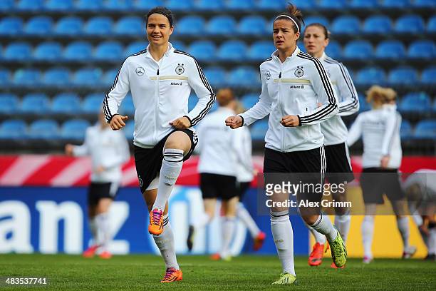 Dzsenifer Marozsan and Lena Lotzen warm up during a Germany training session at Carl-Benz-Stadion on April 9, 2014 in Mannheim, Germany.