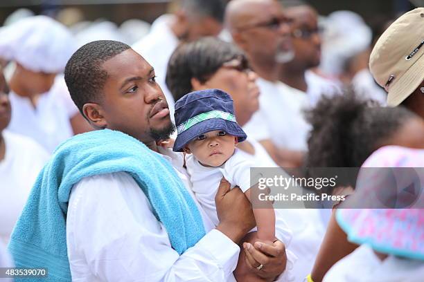 Little girl with daddy and towel awaiting baptism on 116th Street. The United House of Prayer for All People staged its annual street baptism in...