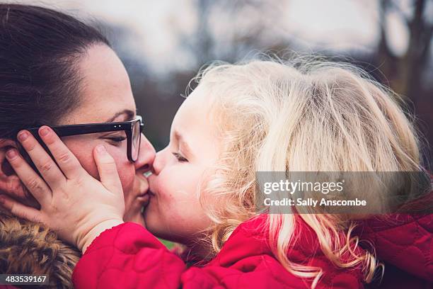 little girl giving her mummy a big kiss - beso en la boca fotografías e imágenes de stock
