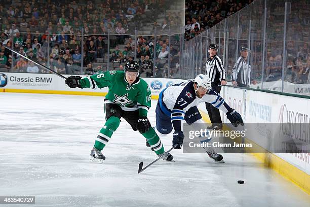 Eric Tangradi of the Winnipeg Jets tries to keep the puck away against Ryan Garbutt of the Dallas Stars at the American Airlines Center on March 24,...