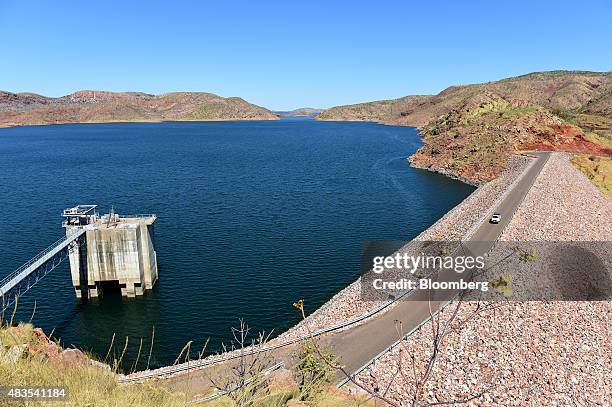 Vehicle drives across a dam wall as the input control tower of the Ord River hydro power plant stands in Lake Argyle, 70 kilometers south of...