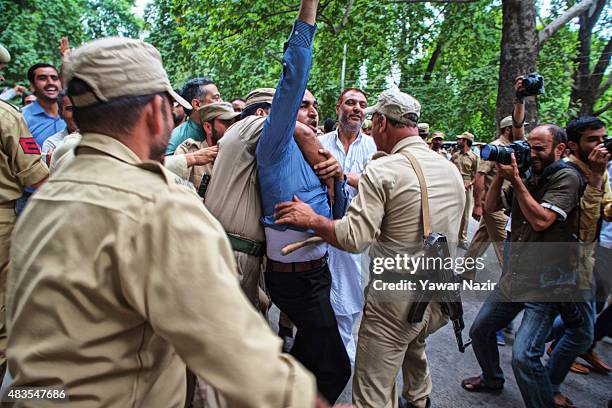 Indian police detain a Kashmiri government employee during a protest against the government on August 10, 2015 in Srinagar, the summer capital of...