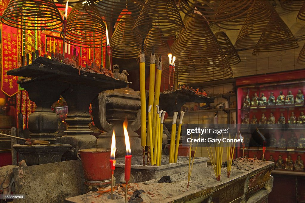 Candles and incense burn at temple