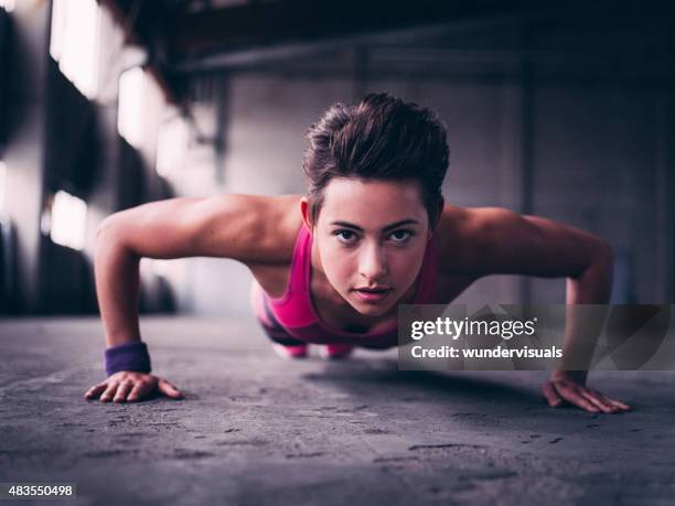 teen girl doing push ups on a concrete floor - action face stock pictures, royalty-free photos & images