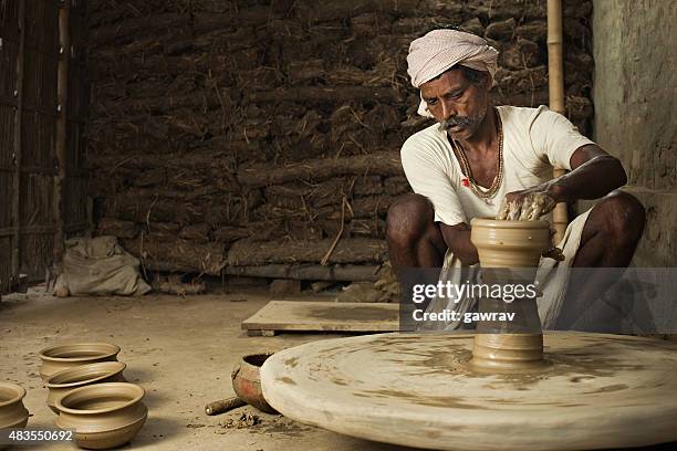 traditional indian potter making clay pot on manual pottery wheel. - pottery stock pictures, royalty-free photos & images