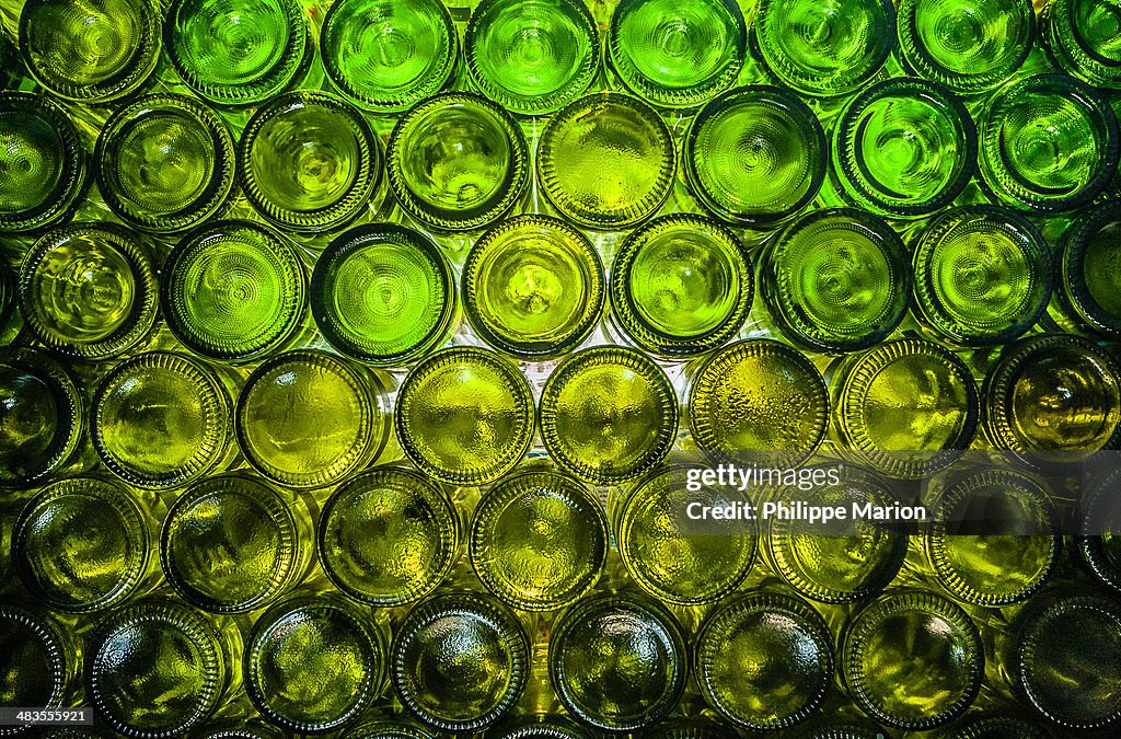 Wall of empty green wine bottles
