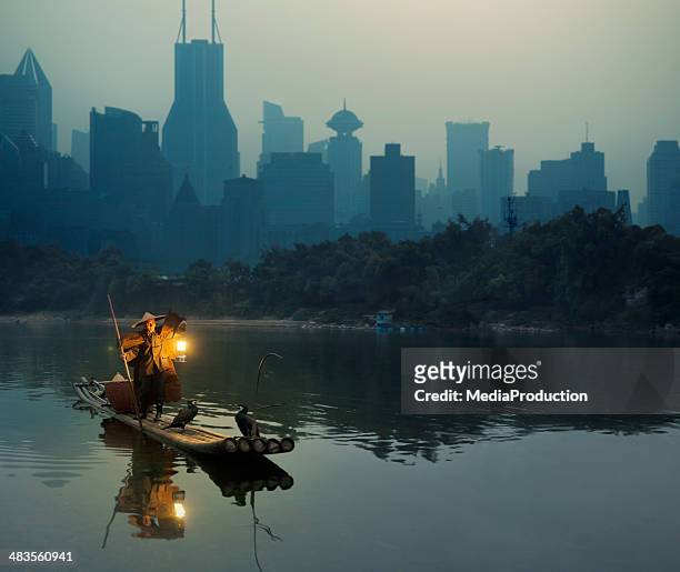 cormorano pescatore in shanghai contro sfondo città di - bamboo raft foto e immagini stock