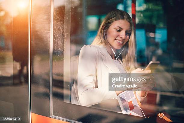 jeune femme dactylographie sur son téléphone intelligent dans les transports en commun. - express photos et images de collection