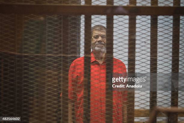Former Egyptian President Mohamed Morsi stands inside the defendants' cage in a courtroom at the police academy during his trial over espionage with...