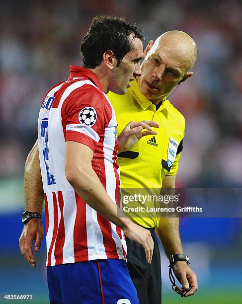 Referee Howard Webb talks to Diego Godin of Club Atletico de Madrid during the UEFA Champions League Quarter Final second leg match between Club...