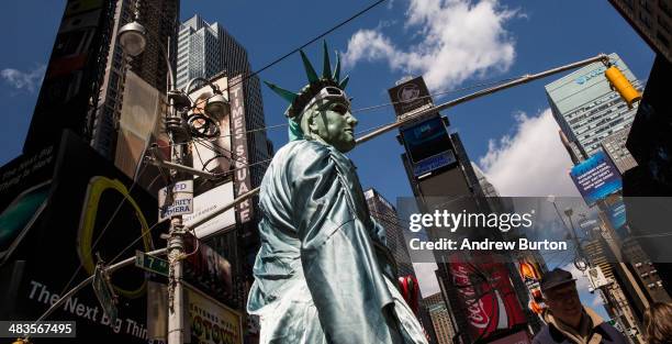 Person dressed as the Statue of Liberty, who poses for photos with people for money, stands in Times Square on April 9, 2014 in New York City. The...