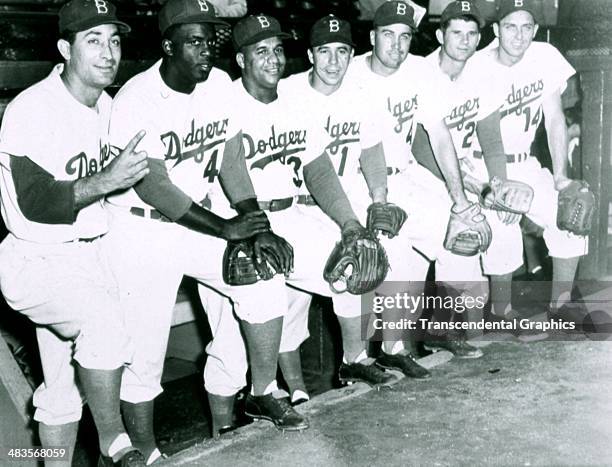 Brooklyn Dodger stars line up on the dugout steps before a game in 1955 in Ebbets Field in Brooklyn, New York. They are Carl Furillo, Jackie...