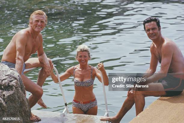 Actors Kirk Douglas , Louis Jourdan and Jourdan's wife Quiquie enjoying the water at the Hotel du Cap-Eden-Roc in Antibes on the French Riviera,...