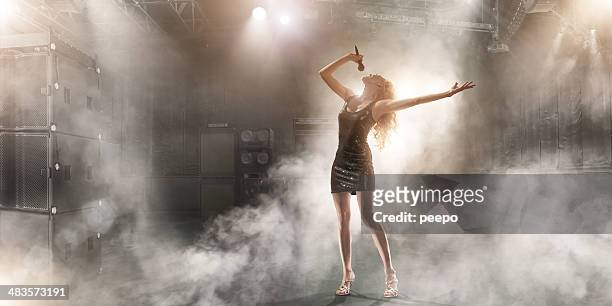 attractive singer performing on stage - popmuzikant stockfoto's en -beelden