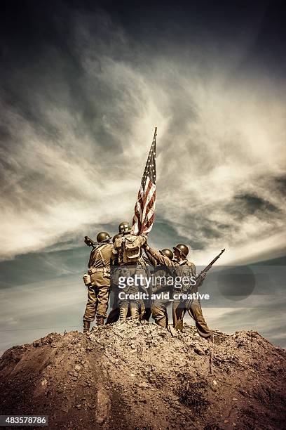 wwii infantry squad hoists flag on hill - infantry stock pictures, royalty-free photos & images