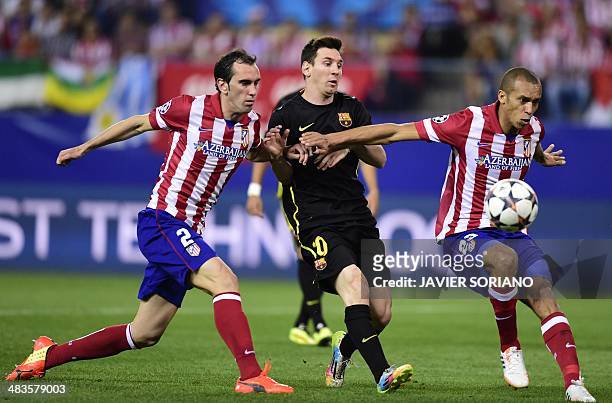 Atletico Madrid's Uruguayan defender Diego Godin and Atletico Madrid's Brazilian defender Joa Miranda de Souza block Barcelona's Argentinian forward...
