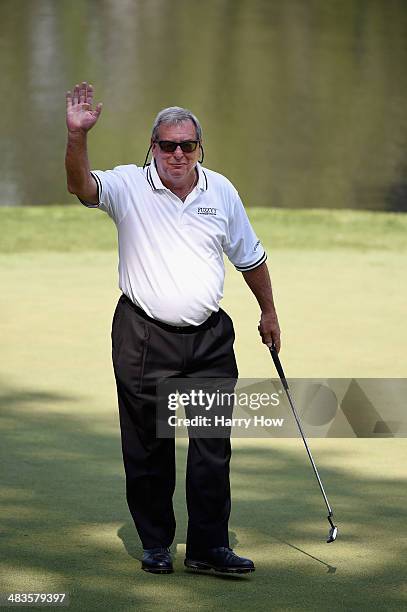 Fuzzy Zoeller waves to the gallery on the ninth green during the 2014 Par 3 Contest prior to the start of the 2014 Masters Tournament at Augusta...