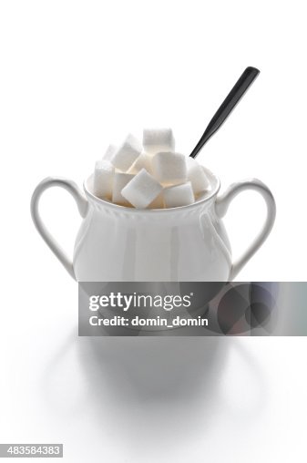 Sugar bowl full of sugar cubes and spoon, isolated on white Sugar bowl full of sugar cubes and spoon, isolated on white