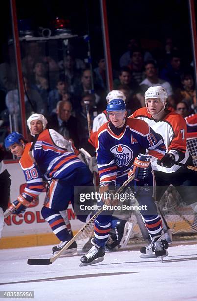 Jari Kurri of the Edmonton Oilers follows the play as Jay Wells of the Philadelphia Flyers defends on November 24, 1989 at the Spectrum in...