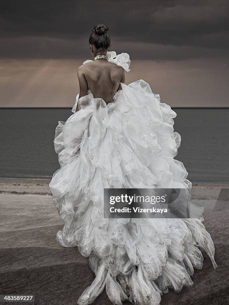 women walking at the beach in plastic bag dress - woman long dress beach stock pictures, royalty-free photos & images