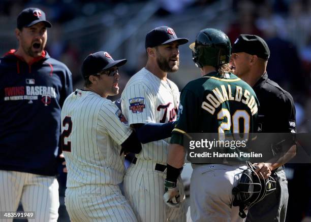 Mike Pelfrey, Brian Dozier and Trevor Plouffe of the Minnesota Twins stop the progress of Josh Donaldson of the Oakland Athletics after Donaldson...