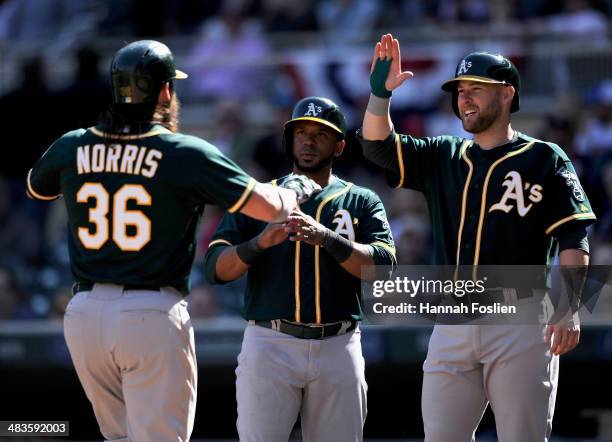 Derek Norris, Alberto Callaspo and Daric Barton of the Oakland Athletics celebrate a three run home run by Norris during the tenth inning of the game...