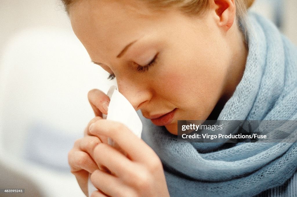 Young woman blowing her nose