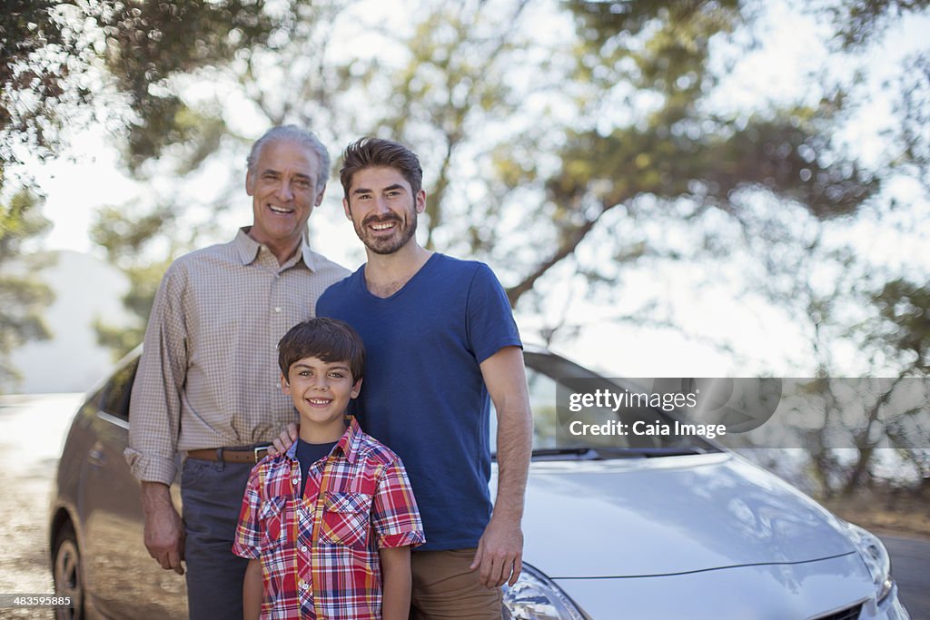 Portrait of multi-generation men outside car