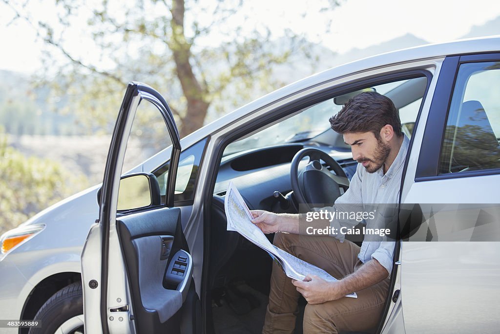 Homme dans la voiture à la recherche à la carte