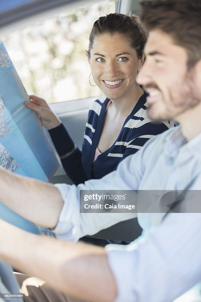 Casal feliz com mapa no interior de Carro