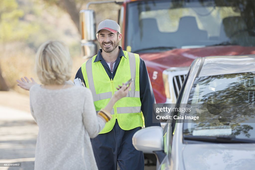 Woman greeting roadside mechanic