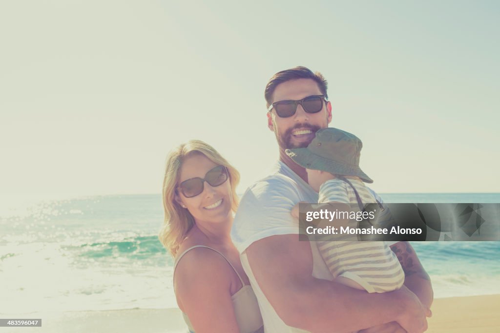 Portrait de famille heureuse sur la plage ensoleillée