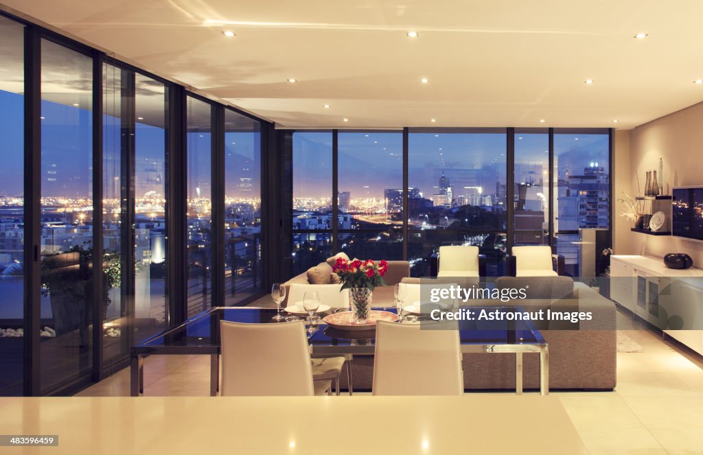 Illuminated modern living room overlooking city