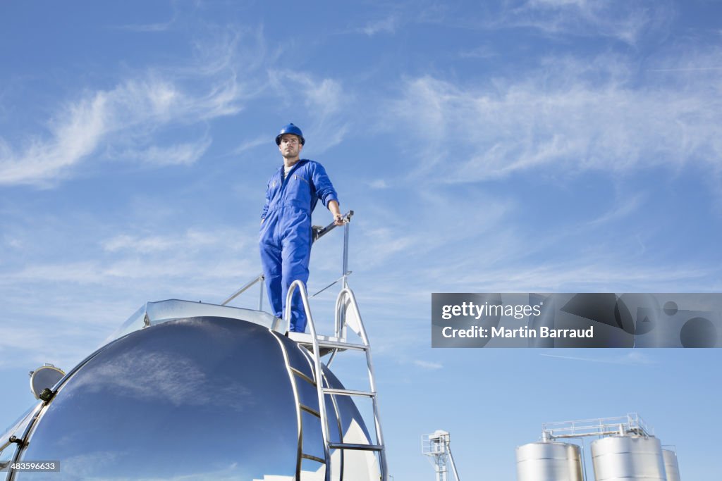 Worker standing on stainless steel milk tanker