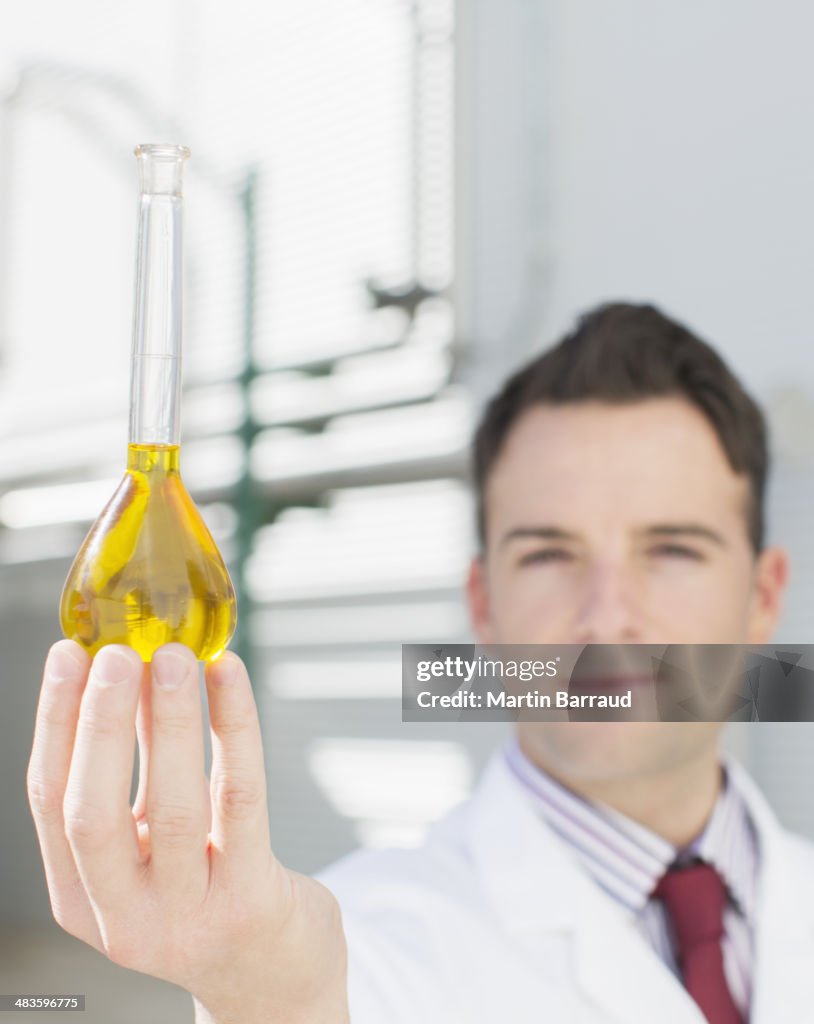 Retrato de um cientista segurando copo com líquido