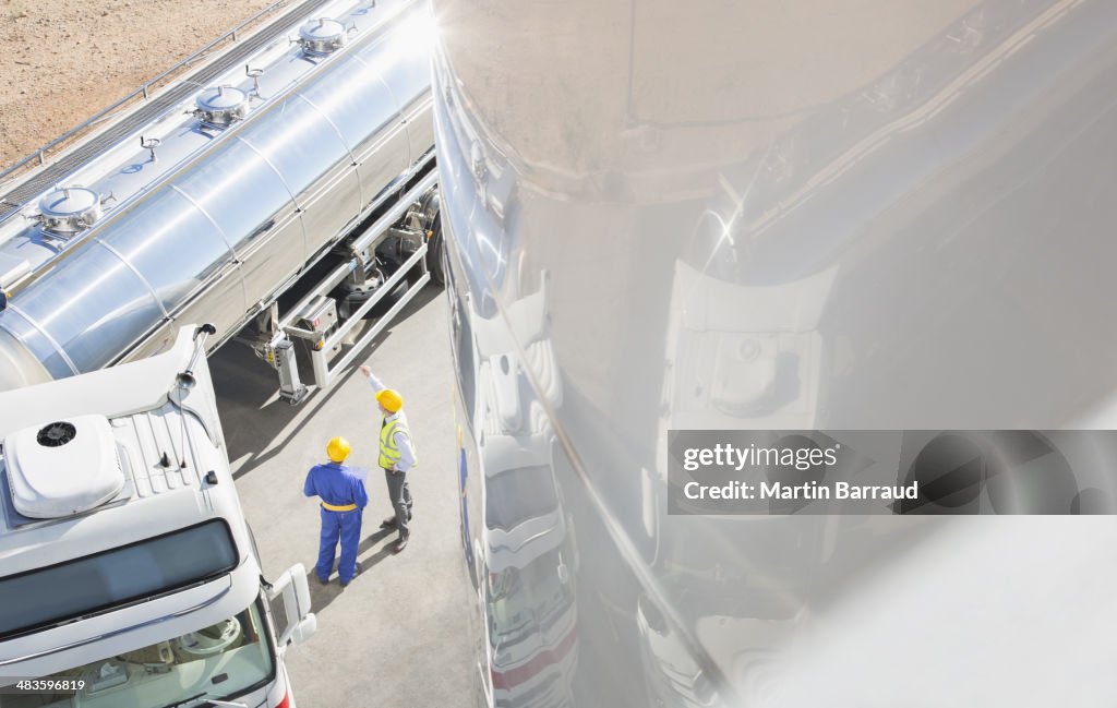 Arbeiter sprechen neben Edelstahl Milchtanker