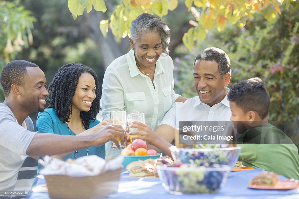 Feliz familia comiendo almuerzo en mesa en el patio