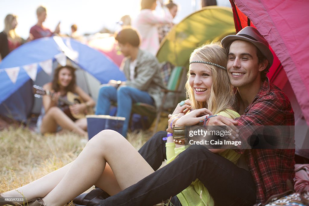 Couple hugging outside tent at music festival