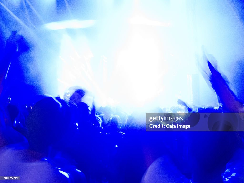 Silhouette of crowd facing illuminated stage