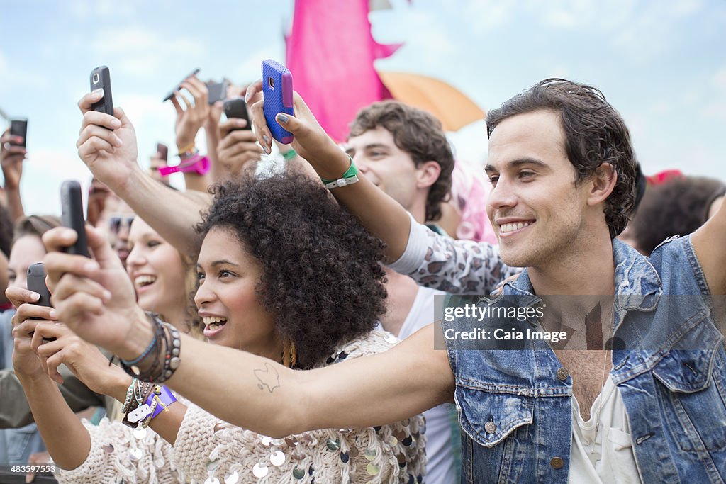 Fans with camera phones cheering at music festival