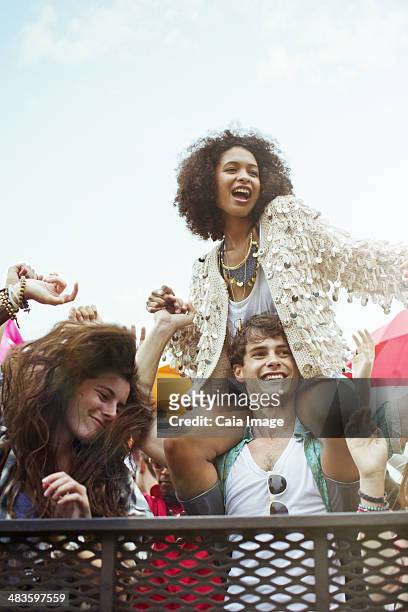 cheering woman on manês shoulders at music festival - on shoulders stock pictures, royalty-free photos & images