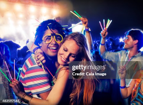 Couple with glow sticks hugging at music festival Couple with glow sticks hugging at music festival